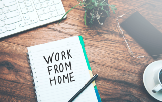 work desk with notebook that reads "work from home"