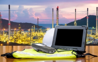 Smart factory - Rugged computers tablet in front of oil refinery industry.