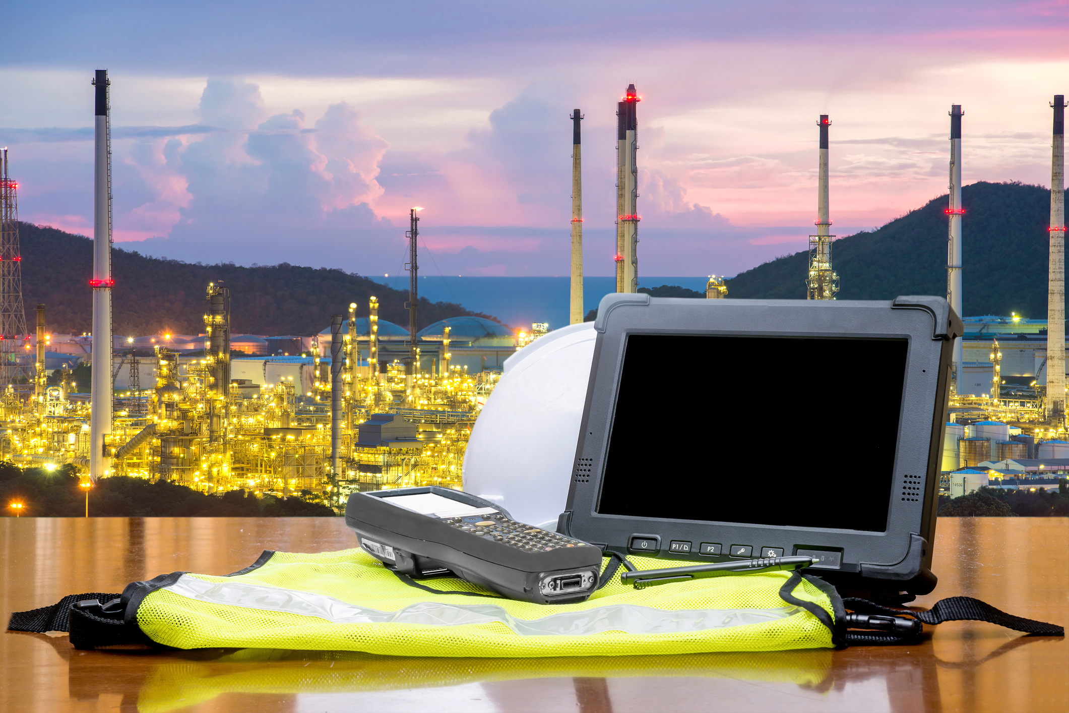 Smart factory - Rugged computers tablet in front of oil refinery industry.