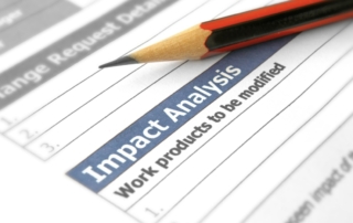 Canva image. The image shows a close-up of a document labeled "Impact Analysis" with the phrase "Work products to be modified" underneath. A sharpened pencil is positioned diagonally on the document, emphasizing the text. The image suggests an analysis or evaluation process, with the pencil symbolizing planning or marking important points. The context appears to involve reviewing or modifying work processes or products based on the impact analysis findings.