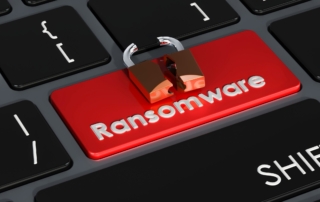 Ransomware impact assessment. The image shows a close-up of a computer keyboard with a red key labeled "Ransomware." The word "Ransomware" is printed in white, contrasting sharply with the red background of the key, which signifies urgency or a threat. Positioned on top of the "Ransomware" key is a small icon of a broken padlock, symbolizing a security breach or vulnerability. This visual metaphor suggests the concept of ransomware as a pressing cybersecurity threat, warning users about the potential risk associated with it.