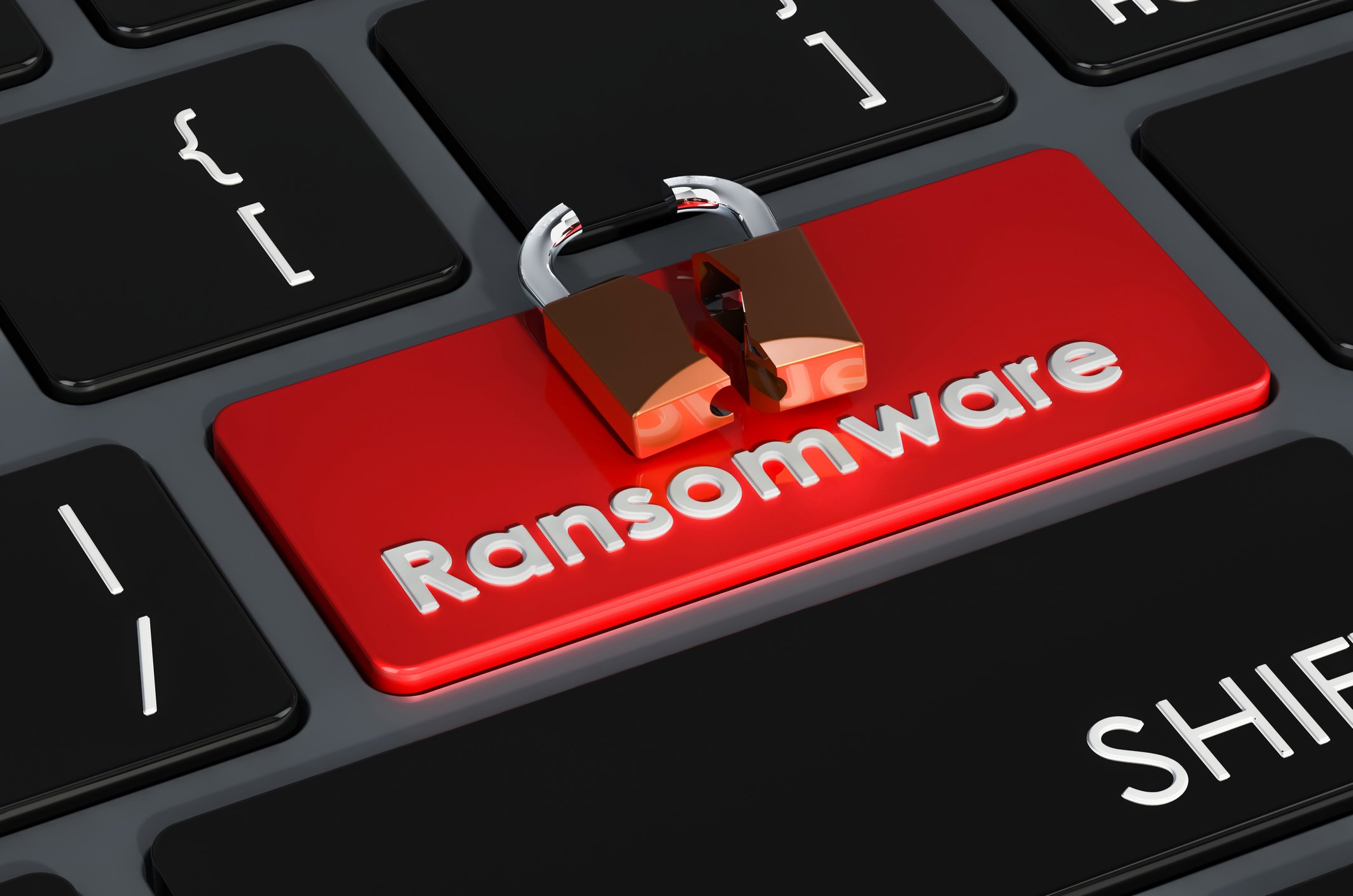 Ransomware impact assessment. The image shows a close-up of a computer keyboard with a red key labeled "Ransomware." The word "Ransomware" is printed in white, contrasting sharply with the red background of the key, which signifies urgency or a threat. Positioned on top of the "Ransomware" key is a small icon of a broken padlock, symbolizing a security breach or vulnerability. This visual metaphor suggests the concept of ransomware as a pressing cybersecurity threat, warning users about the potential risk associated with it.