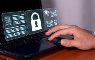 Preparing business for ransomware attack. The image shows a person's hand resting on the touchpad of a laptop, symbolizing interaction with technology. Floating above the laptop screen are three glowing, semi-transparent icons that resemble digital interface elements. The center icon features a large white lock, symbolizing security or protection of data. The icons on either side of the lock display digital text and symbols, resembling documents, encrypted files, or technical data. The overall design conveys themes of cybersecurity, data access control, and secure technology usage. The clean and futuristic look suggests a focus on digital solutions and online security measures. The neutral background keeps attention on the hand, laptop, and digital interface.