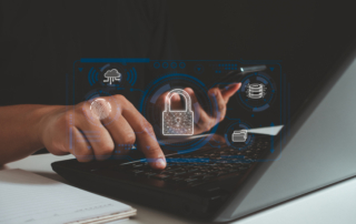 Business continuity planning for ransomware. This image features a person interacting with a laptop, their hand poised over the keyboard while pointing at the screen. Superimposed over the scene are digital, holographic-style graphics related to cybersecurity and data technology. The most prominent symbol is a glowing padlock in the center, symbolizing security. Surrounding it are icons representing a cloud, a fingerprint (likely denoting biometric access), a folder, and a database stack. The layout has a high-tech, futuristic vibe, emphasizing themes of secure data, digital storage, and technological advancement. The person is likely engaging in an activity related to these concepts, such as secure login or data management.