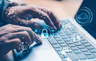 Machine learning for ransomware prevention. Hands are typing on a laptop keyboard with a futuristic digital overlay. The overlay features glowing blue security icons, including a padlock, gears, and cloud symbols, signifying online security, system settings, and cloud data protection.