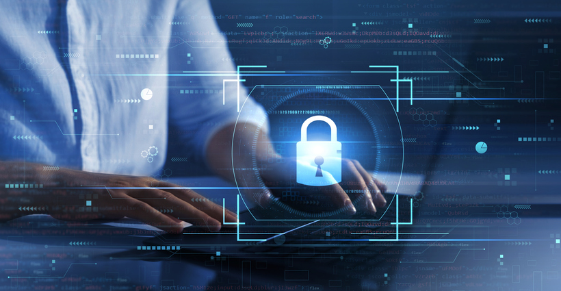 Ransomware attack containment. This image shows a person typing on a laptop, with their torso and hands in focus. Overlaying the scene are futuristic, holographic-style elements emphasizing cybersecurity. At the center is a glowing padlock icon, surrounded by digital frames and data lines, symbolizing protection and secure access. The background features a digital interface with scattered dots, lines, and faint text, creating the appearance of a high-tech environment. The person’s white shirt contrasts with the dark and blue-toned surroundings, reinforcing the theme of digital security and data interaction.