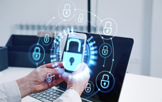 Ransomware trends and innovations. A person is holding a smartphone in front of a laptop. A glowing holographic overlay depicts multiple lock icons connected by lines, symbolizing mobile and network security, as well as the integration of secure technology across devices.