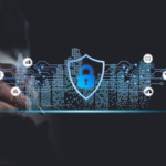 Endpoint protection for ransomware defense. A hand holding a stylus hovers over a digital surface. A glowing blue shield with a padlock appears in front of a futuristic cityscape made of lines and dots, symbolizing digital protection for urban networks.