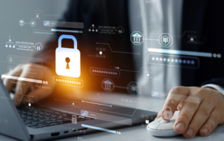 On-premises vs. cloud recovery solutions. A person in formal business attire is working on a laptop while using a mouse. A holographic overlay appears in front of the screen, featuring a large glowing padlock symbol, representing cybersecurity and data protection. Surrounding the lock are various digital interface elements, including security ratings, authentication fields, and shield icons, suggesting encryption, secure access, and compliance. The lighting and reflections give the image a futuristic, tech-driven feel.