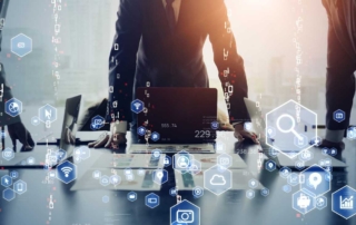 Encrypted Backup Services. Several people in business attire stand around a conference table with laptops open. The scene is overlaid with floating digital icons — like magnifying glasses, graphs, Wi-Fi symbols, cloud storage, and security shields — suggesting a high-level meeting about technology, cybersecurity, or digital strategy. Warm light filters through the background.
