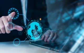 Ransomware-as-a-Service Insights. A person in a business suit points at a glowing holographic globe, with other transparent icons and lines radiating from it, positioned over a laptop keyboard.